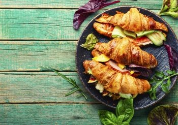 Fresh croissants with salted filling.Croissants with salmon, bacon, figs and cucumber.Copy space. Fresh croissants with meat and fish