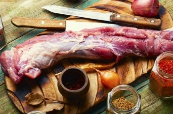 Appetizing raw pork meat for cooking. Raw meat and spices set. Uncooked pork tenderloin, fresh meat