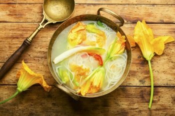 Soup with rice noodles and pumpkin flowers.Asian vegan soup.. Vegan noodle soup with zucchini flowers