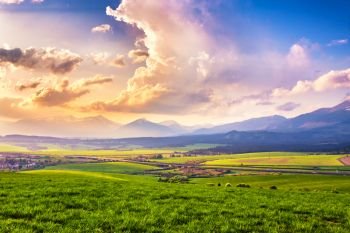 Spring mountain valley. Picturesque green fields and meadow landscape. Panorama of Slovakia Tatras mountains in spring. Grass fields, Pieniny