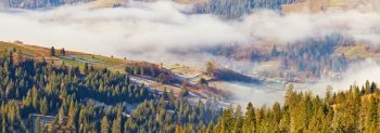 Mountain morning autumn panorama. Colorful fall landscape, foggy sunrise in Carpathians.
Majestic misty scenery, valley, village,  tonal perspective
