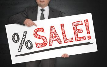 Sale poster is held by businessman.. Sale poster is held by businessman