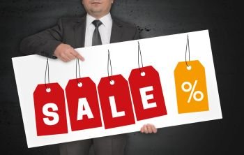 Sale labels poster is held by businessman.. Sale labels poster is held by businessman