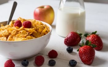 Cornflakes in a bowl with milk and fruits.. Cornflakes in a bowl with milk and fruits
