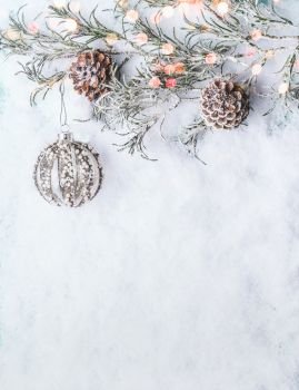 Christmas background  with vintage bauble , frozen branches and cones on snow with bokeh, top view with copy space for your design, border