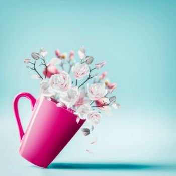 Cup with lovely spring blossom bunch of magnolia and falling petals at light blue background, close up . Flowers arrangement. Valentines, Women’s, Wedding Day concept. Vertical. Copy space