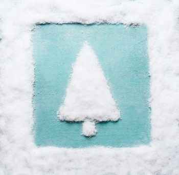 Christmas tree made with snow with snow frame at blue background. Modern creative winter holiday concept