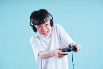 Young teenage boy playing excited with game controller .