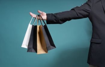 Unknown businessman hold the shopping paper bag , bargain sale concept .