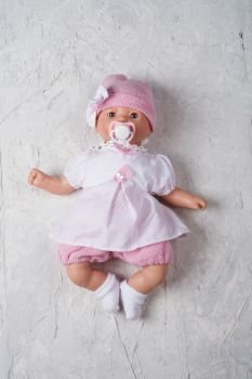 cute baby doll tot with dummy around white background