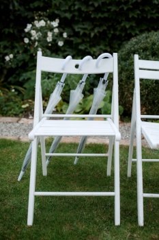 white wooden chairs for wedding ceremony on green grass
