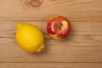 Lemon and apple on a wooden background. View from above .. Lemon and apple on a wooden background.
