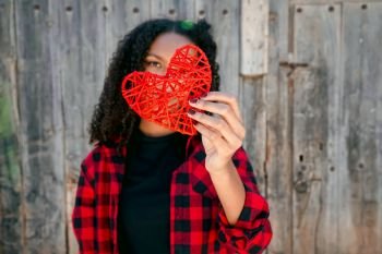 Beautiful young woman holding a red heart