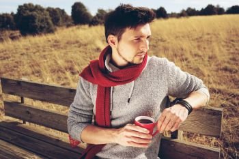 Young man enjoying a sunny morning drinking a cup of coffee                               