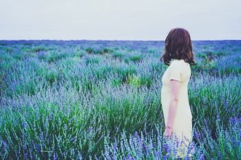  Back view of a young woman in a field of lavender                              
