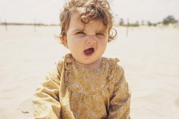 Little girl playing with sand at the beach