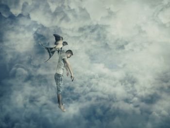 Flying bird carrying a powerless young boy hanging in her claw. Conceptual image symbolizing manipulation and control as a marionette.