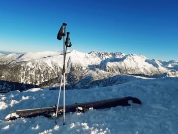 Ski equipment on the top of Todorka peak with a view to snow covered Pirin Mountains.