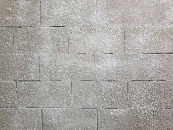 Old grey stone masonry wall texture made of foam blocks or airblocks. Abstract surface plastered. Grunge, weathered construction structure.