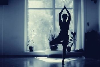 fitness girl yoga silhouette in the room