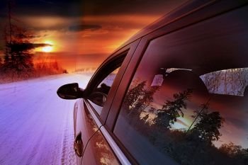 car at sunset in winter landscape