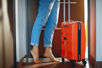 girl with a red suitcase leaves the room, the concept of tourism, departure, fees for the trip