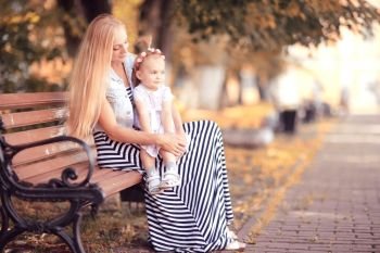 mom with a little girl on a park bench