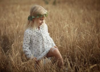 blonde little girl in the field with spikelets