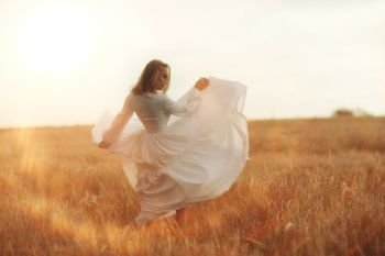 girl dancing in a field in white dress