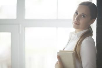 Young adult girl with book learning, reading, business