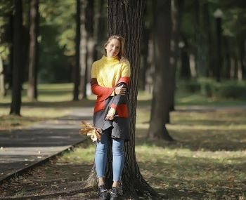 autumn view, one girl walks in the park / yellow leaves, autumn park, a lonely girl is resting in autumn park