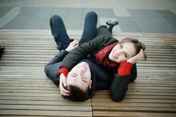 couple cuddling on a bench in winter
