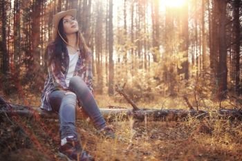 Beautiful girl in the forest landscape with sun rays