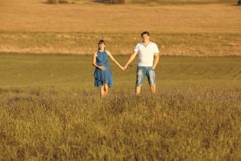 man and a pregnant woman in a summer field