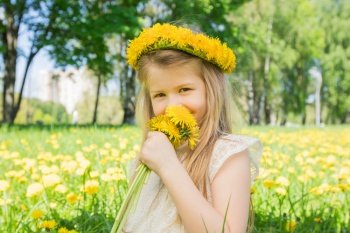 Little girl enjoys the smell of flowers in the meadow. Little girl enjoys the smell of flowers