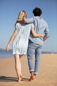 couple are walking together at the beach