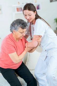 Doctor helping an old lady to stand