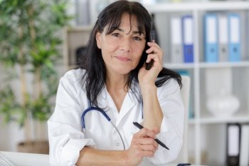 busy medical doctor on the phone with receptionist