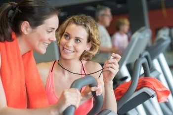 trainer assisting woman at gym