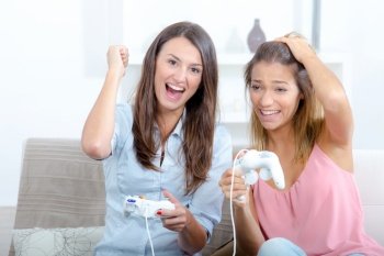 two happy competitive friends playing video games