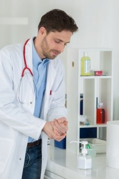 medical doctor using sanitizer dispenser