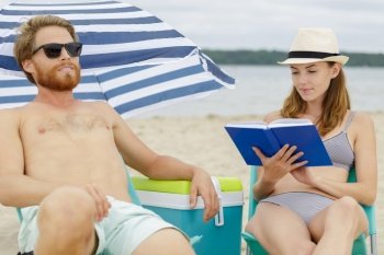 girlfriend reading a book on the beach