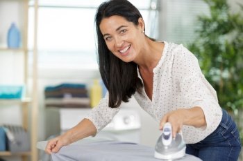 beautiful older woman ironing clothes