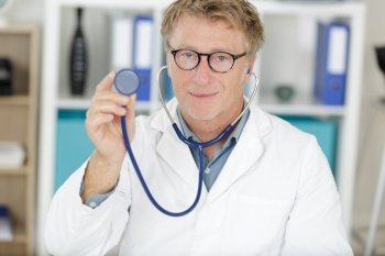 handsome doctor man showing his stethoscope