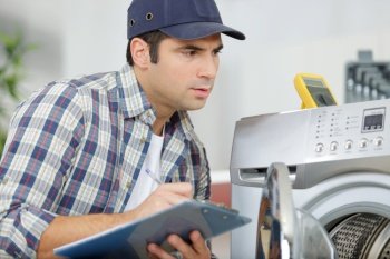 male technician writing the manufacturers code