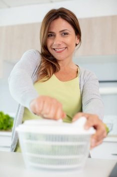 happy young housewife mixing vegetable salad