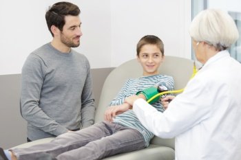 female doctor examining little boy in hospital