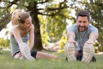 fitness couple stretching outdoors in park
