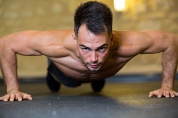 portrait of a concentrated young sportsman doing plank exercise