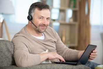 handsome young man using laptop computer with headset